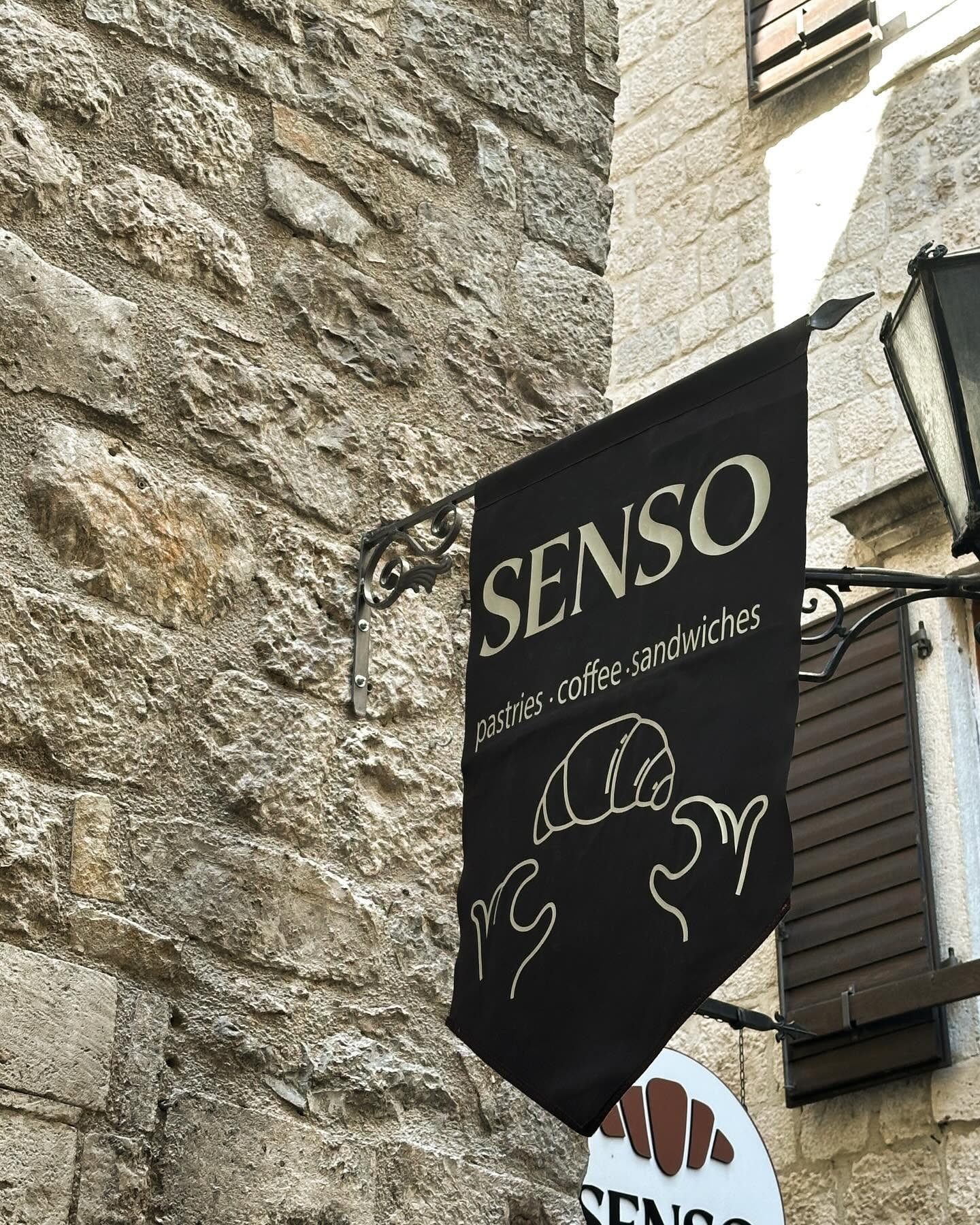 Senso crna zastava sa natpisom 'pastries, coffee, sandwiches' na kamenom zidu Starog grada