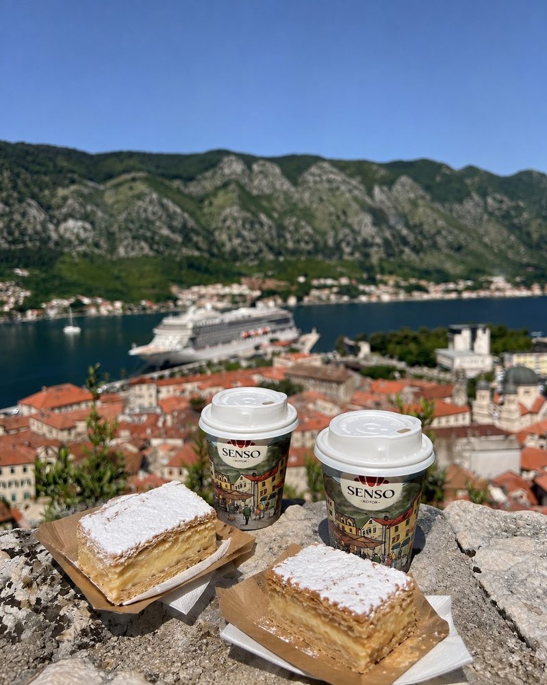 Senso šoljice za poneti i krempite na kamenom zidu, sa pogledom na Stari grad Kotora i zaliv